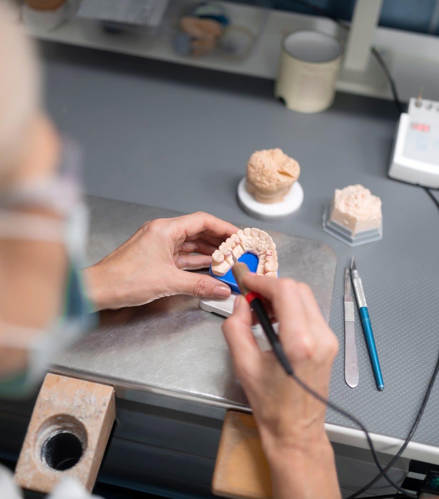 A master ceramist hand-layering a porcelain veneer in the lab